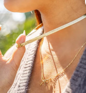 Close-up of a person wearing a gold necklace 