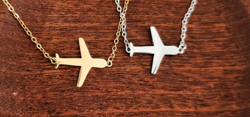 Two airplane-shaped pendants on gold and silver chains that can be personalized